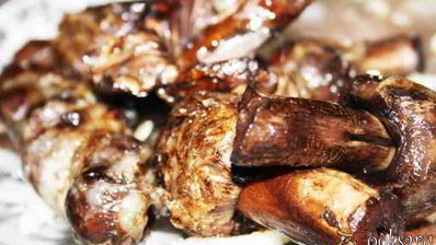 луговые шампиньоны в жировой сетке на мангале