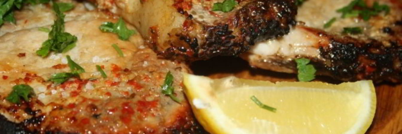 Свиная котлета на косточке с паприкой и кунжутом на липовой дощечке на мангале