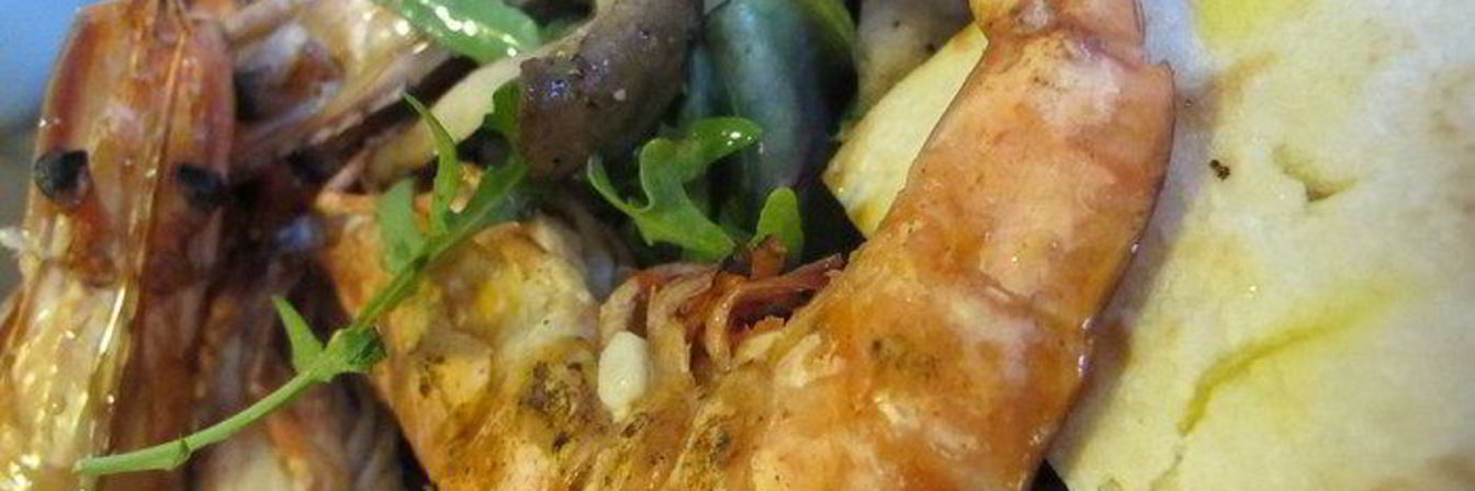 Тигровые креветки с табаско, лимоном и чесноком на листовой подушке с теплой питой