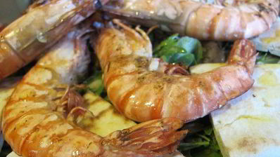 тигровые креветки с табаско, лимоном и чесноком на листовой подушке с теплой питой